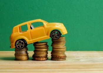 close up toy car stack coins against green wall 1 scaled
